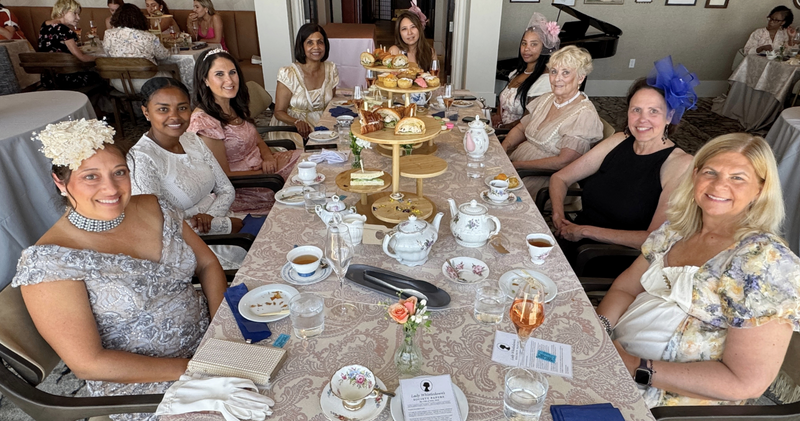 Guests gathered around a decorated table at the University Club of San Diego for the Bridgerton High Tea event.